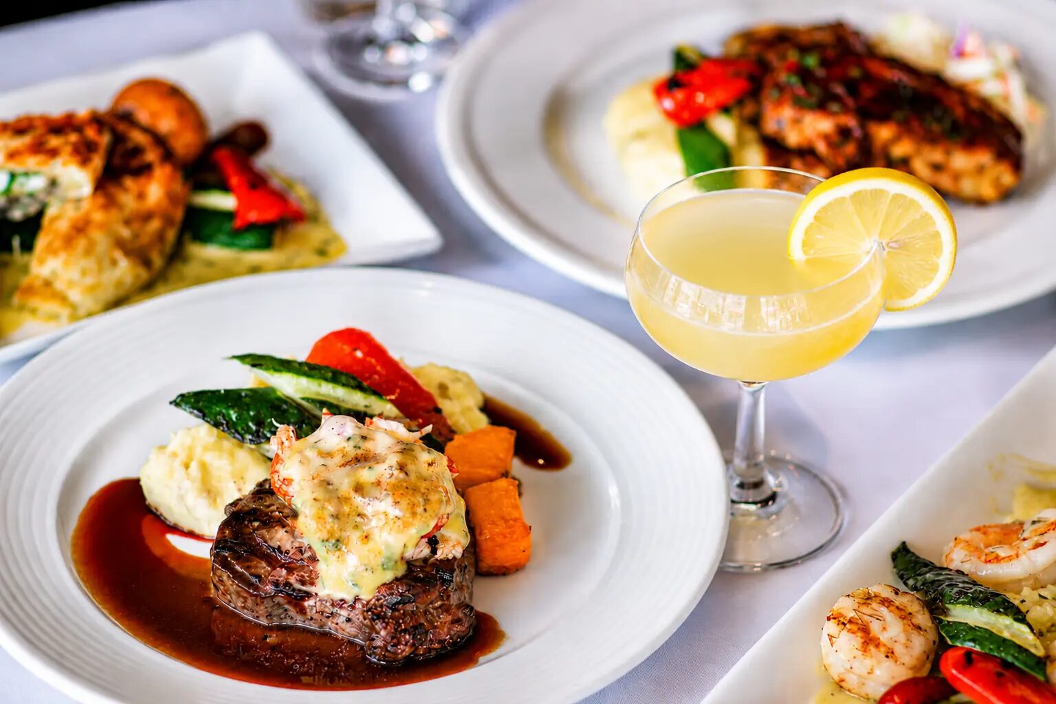 Plated beef filet with mashed potatoes, grilled vegetables and a cocktail