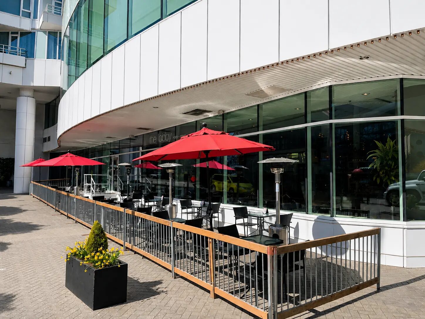 The Lobby outdoor patio with red umbrellas by the water