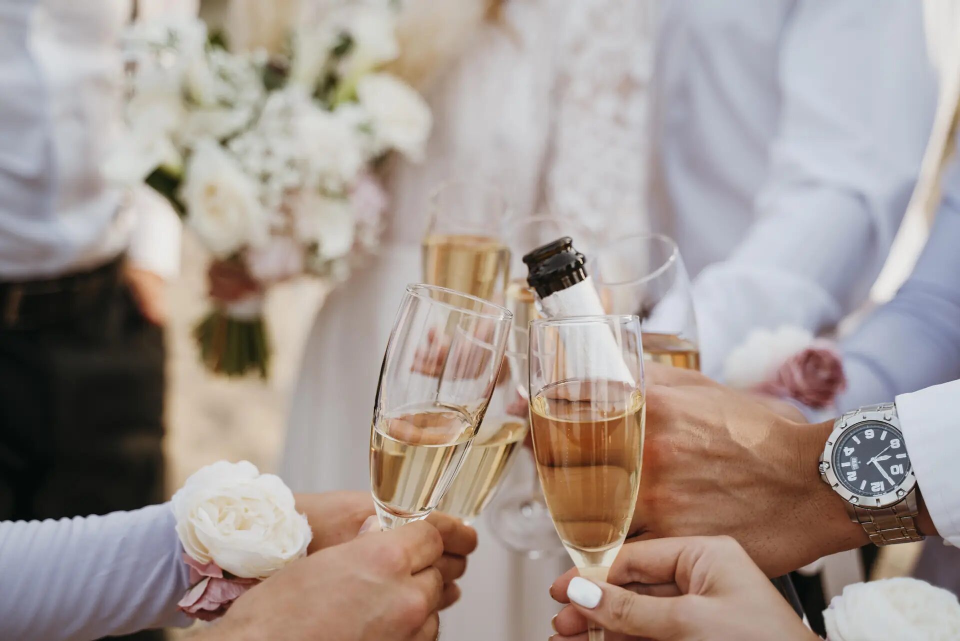 Guests raising champagne glasses in a toast at a wedding